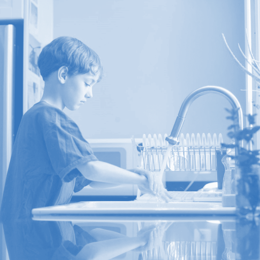 A boy washing his hands at the kitchen sink