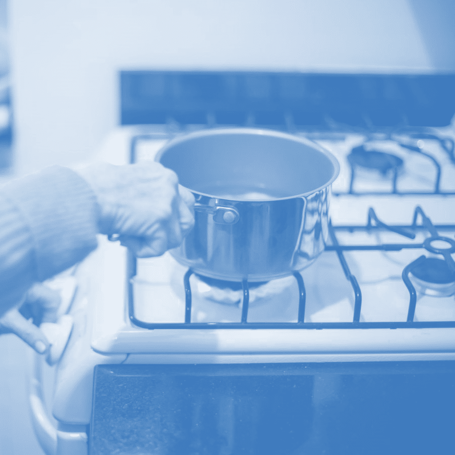 A person with a pot on a stove