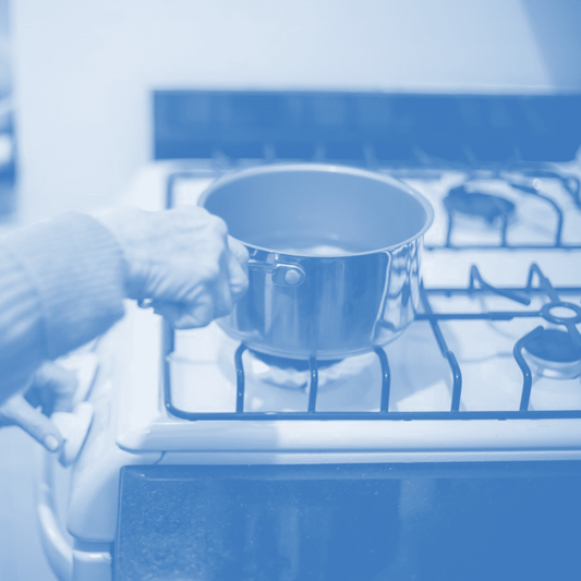 A person with a pot on a stove